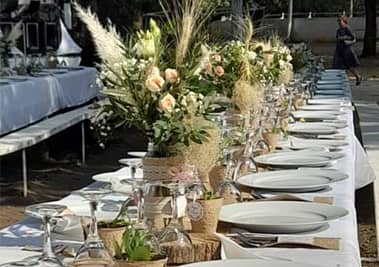 Table de mariée décorée de bouquets de fleurs avec des plats en forme de tronc d'arbre
